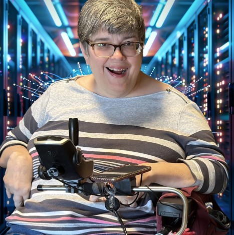 "Image of a woman sitting in a wheelchair in a room full of servers"