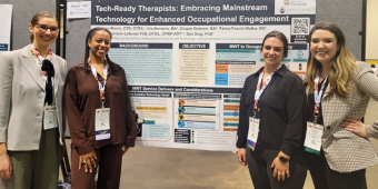 Lindsey Morris, Nia Monteiro, Palma Foschi Walko, and Chapin Graham standing in front of their poster presentation