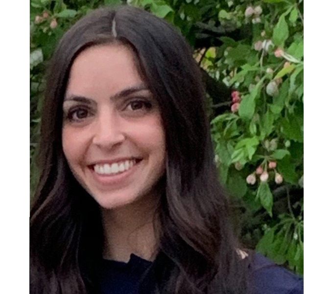 Photo of Gina Novario, a smiling young woman with long black hair wearing a blue shirt